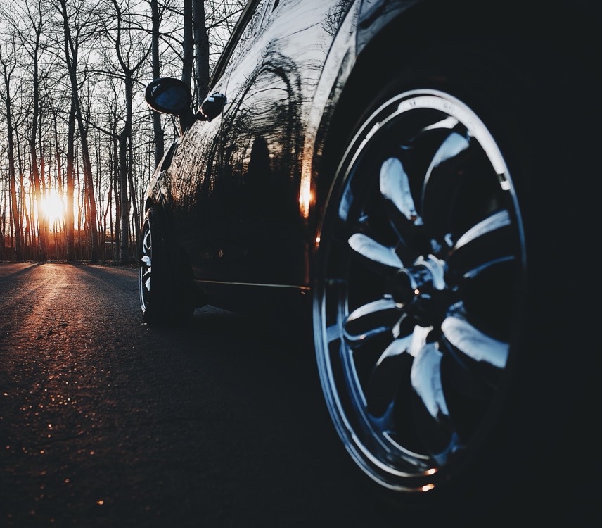 Glossy black paint and a chrome wheel catching the last light of sunset